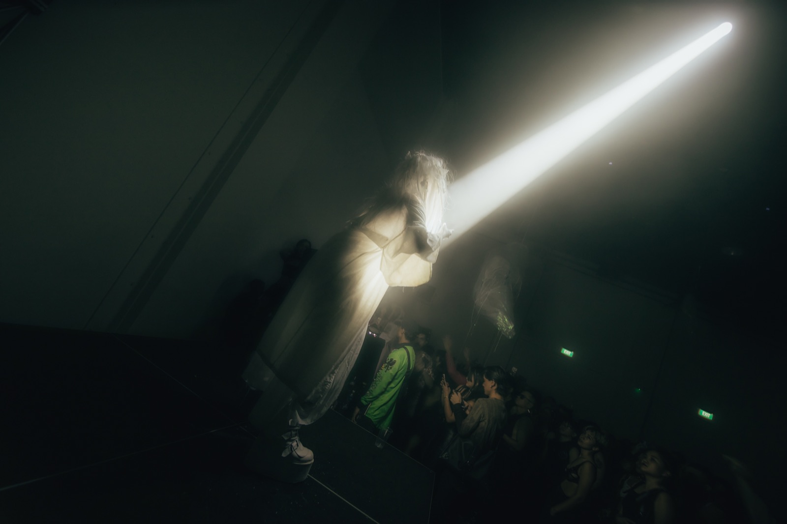 A Butoh performer with a single white light shining on her