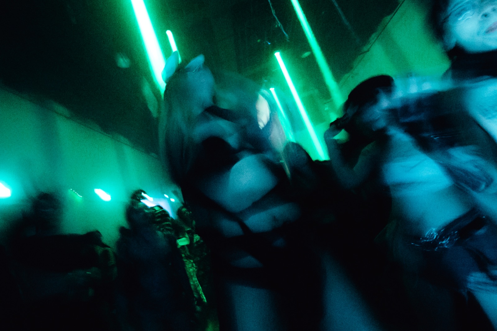 The crowd, blurred, in green light