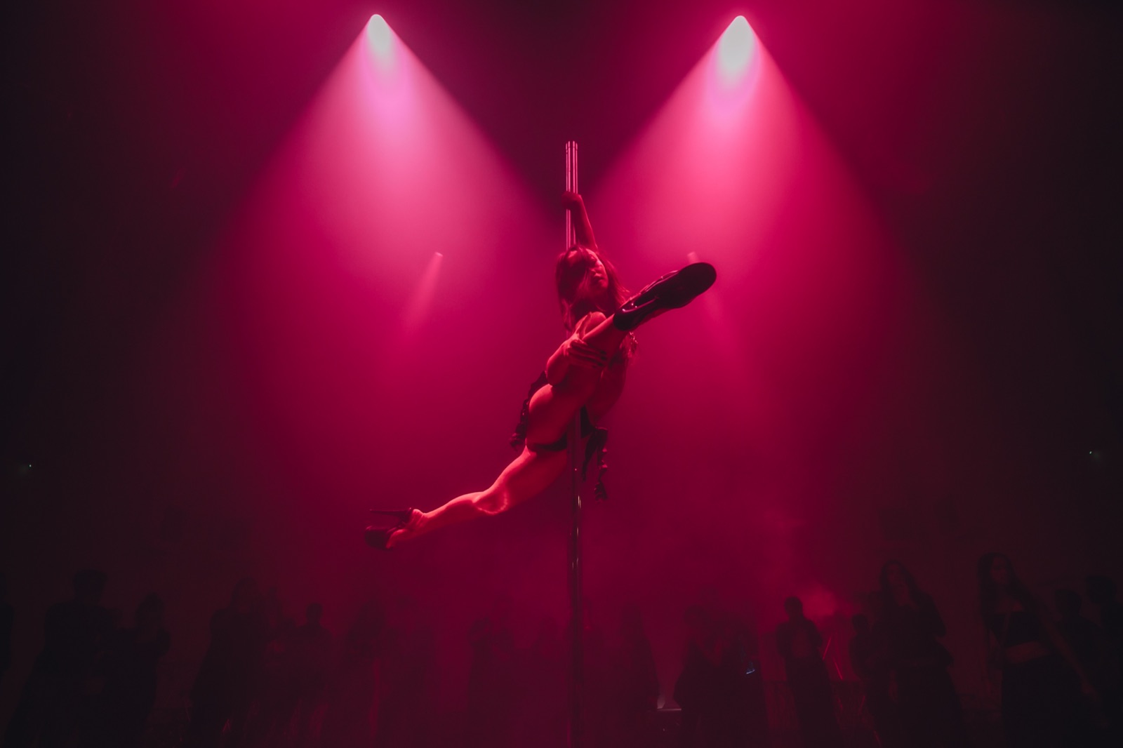A pole dancer spotlighted in red light