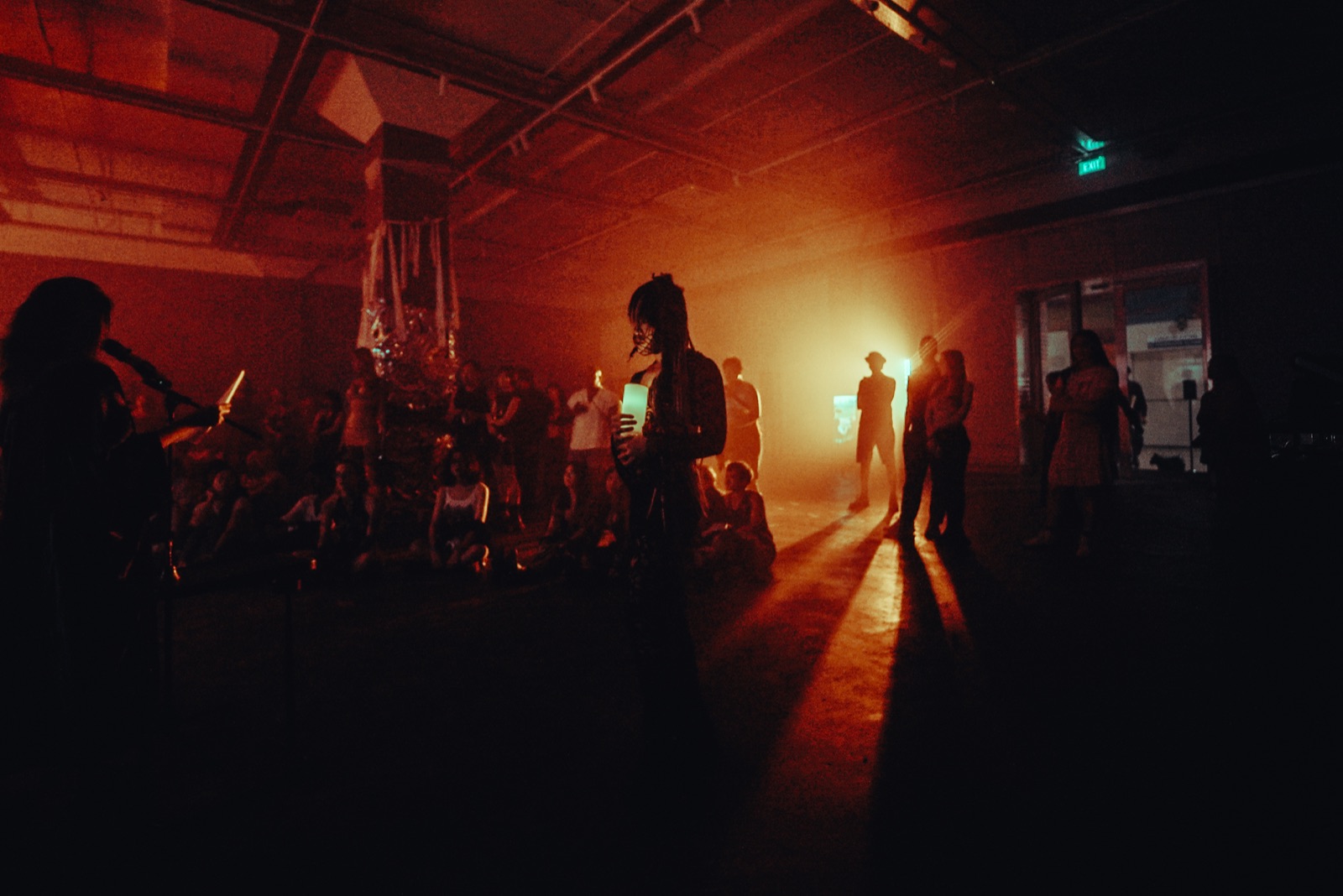 A performance artist, seen from afar in orange light