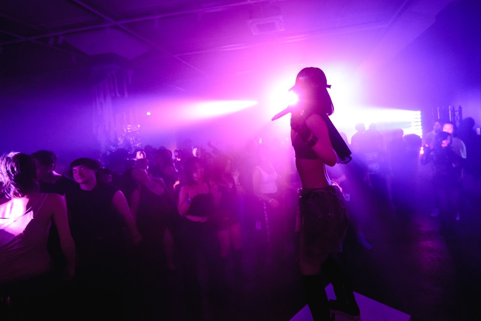 Pink light over the crowd, someone singing