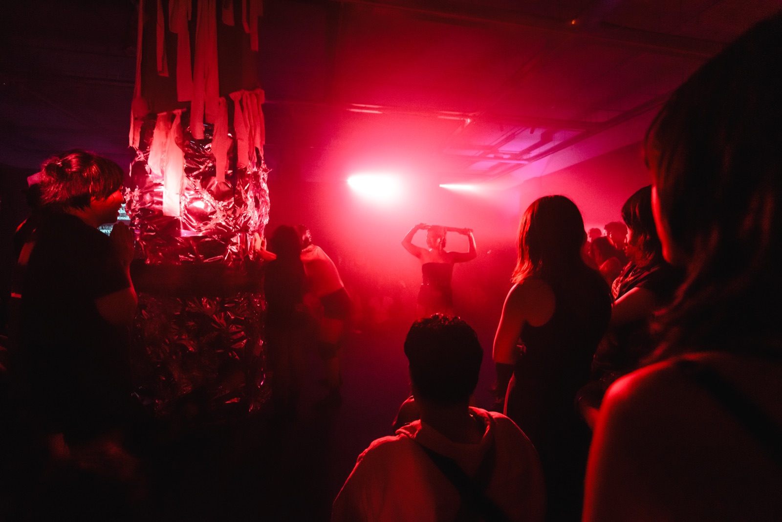 Red light over the crowd, the performer seen from afar