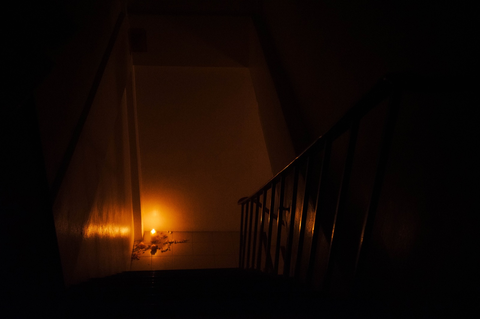 A single candle glowing in the corner of the space