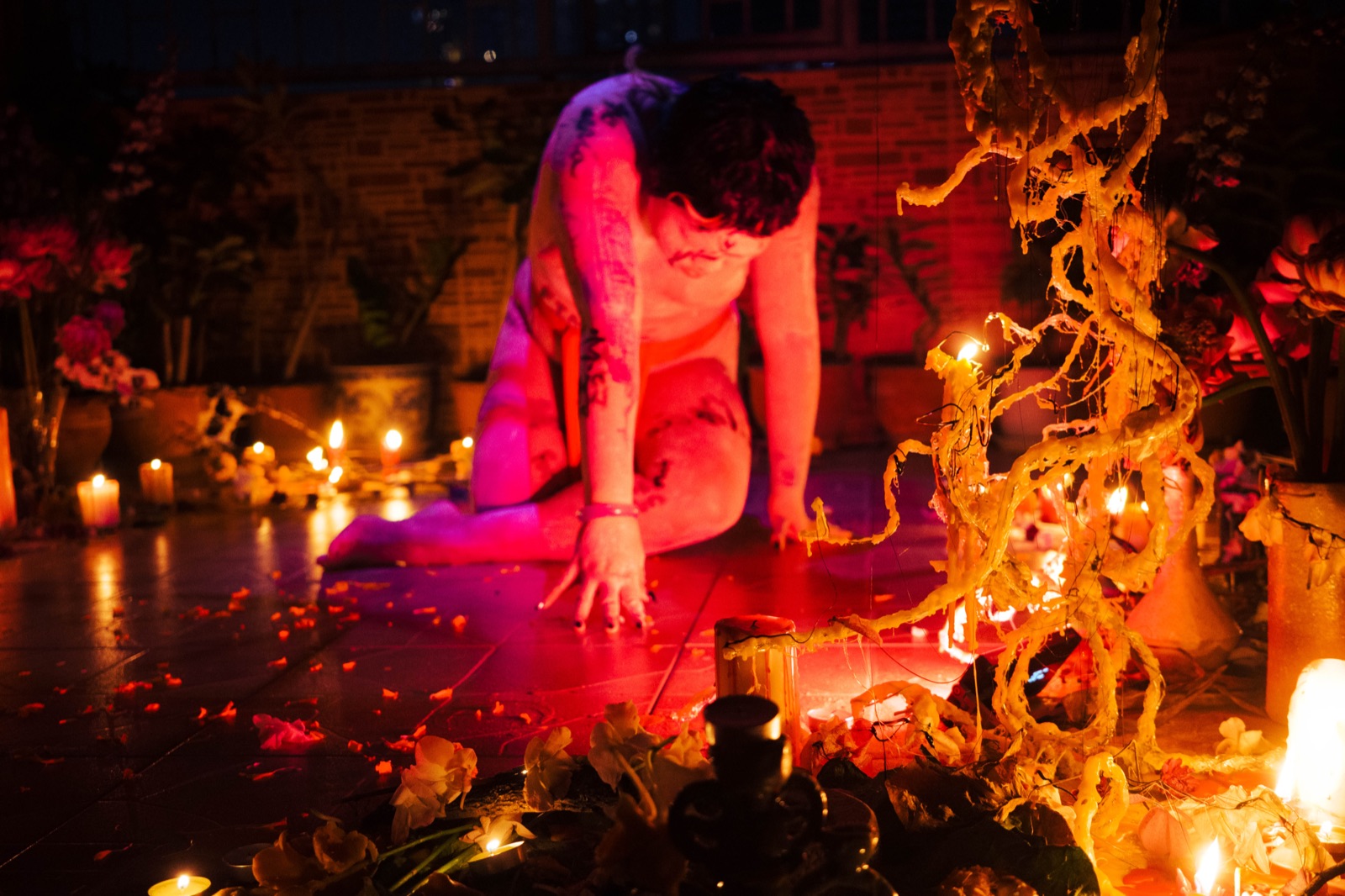 A performer beside Zenon's candle installation