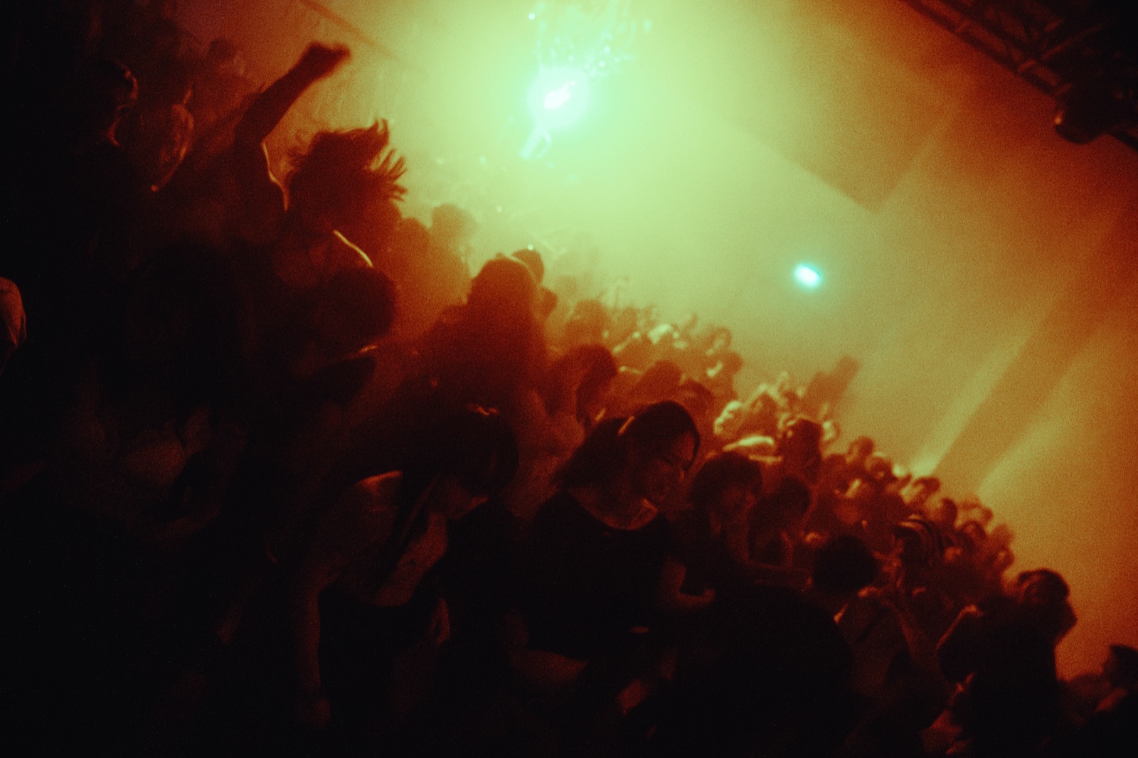 The crowd dancing in the moody, dreamlike light of the rave