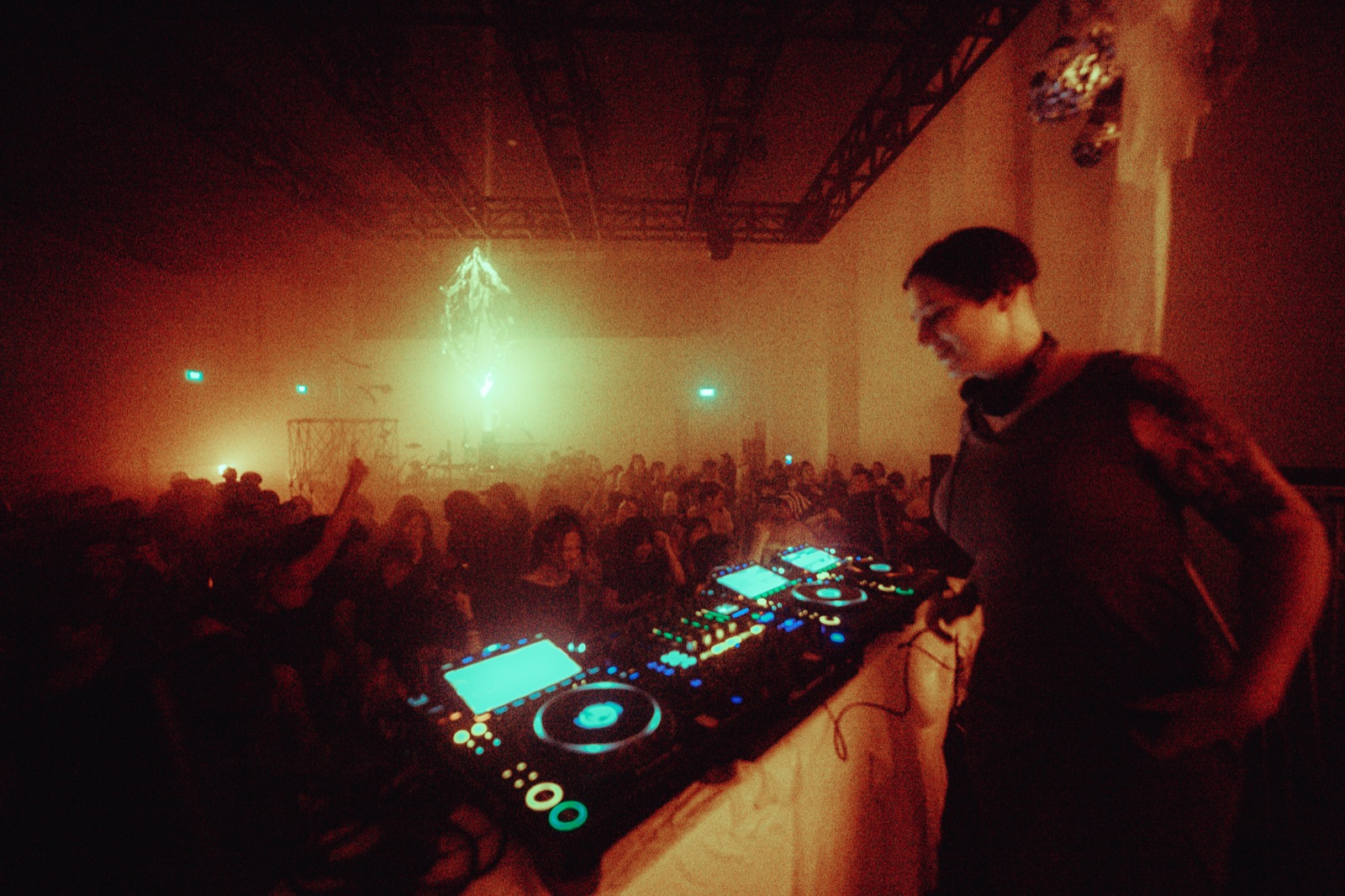 Zenon DJing to the crowd, with the blurred installation behind